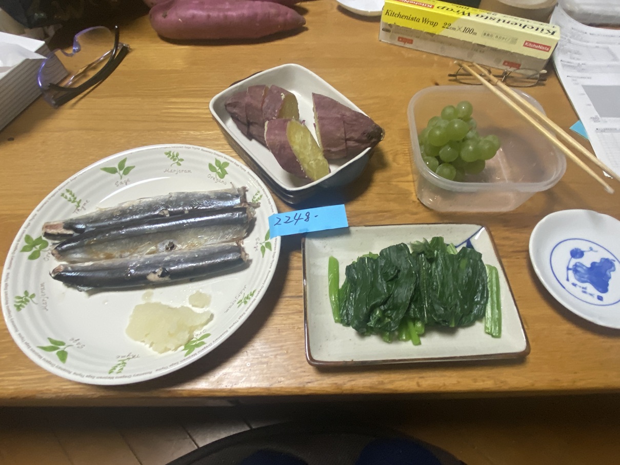 「焼きさんま、さつまいも、小松菜のおひたし、ぶどうを組み合わせた栄養バランスの良い夕食」