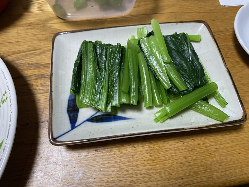 長方形の和皿に盛り付けられた小松菜のおひたし。鮮やかな緑色が食卓に彩りを添える、シンプルで栄養豊富な副菜。