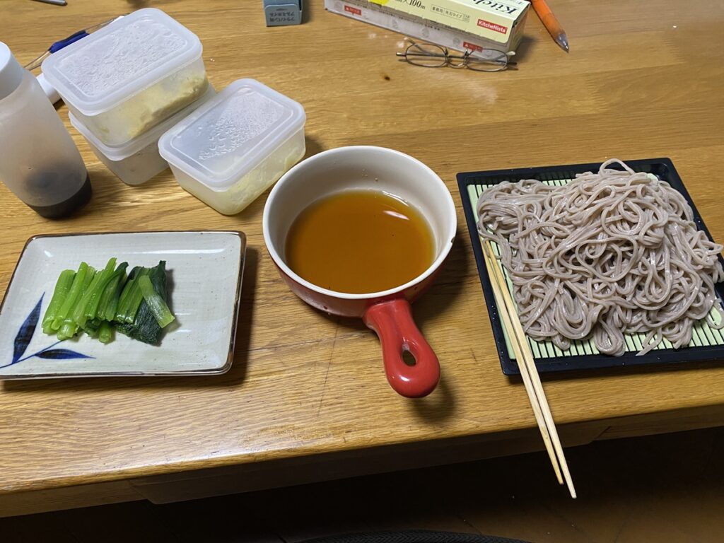 十割そば2人前と小松菜のおひたし、赤い容器のカツオだしを添えた夕食。22時過ぎに食べた手づくりのそば定食。