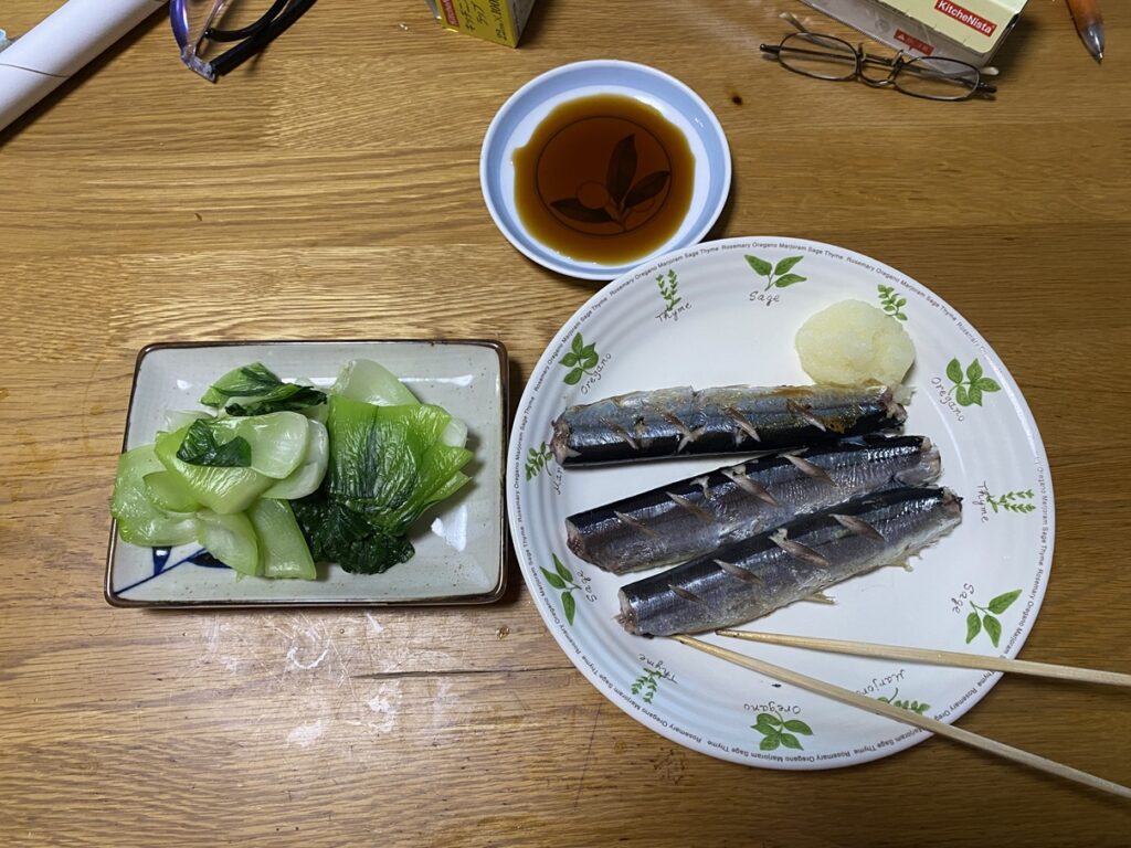 焼きサンマに大根おろしを添えた和食の一皿と、チンゲンサイのおひたし。かつおだし醤油をつけて食べるバランスの良い夕食